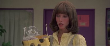 Movie still from “3 Women” (1977), directed by Robert Altman – A woman in a yellow shirt holding a bag of food; Close Up shot, Over the shoulder angle