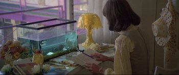 Movie still from “3 Women” (1977), directed by Robert Altman – A woman writing in a notebook at a desk; Medium shot, High angle