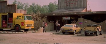 Movie still from “3 Women” (1977), directed by Robert Altman – A couple of men standing in front of a building; Wide shot, Over the shoulder angle