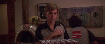 Movie still from “3 Women” (1977), directed by Robert Altman – A young man is standing in front of a bunch of soda cans; Medium shot, Over the shoulder angle