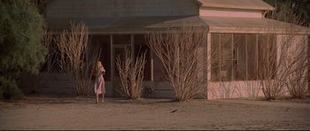 Movie still from “3 Women” (1977), directed by Robert Altman – A woman standing in front of an abandoned house; Extreme Wide shot, Low angle