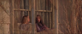 Movie still from “3 Women” (1977), directed by Robert Altman – Two women sitting on a swing in front of a window; Medium shot, Low angle