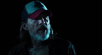 Movie still from “3 from Hell” (2019), directed by Rob Zombie – A man with a beard wearing a baseball cap; Close Up shot, Low angle