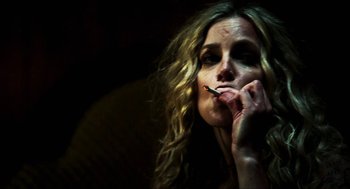 Movie still from “3 from Hell” (2019), directed by Rob Zombie – A woman is smoking a cigarette in the dark; Close Up shot, Low angle