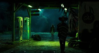 Movie still from “3 from Hell” (2019), directed by Rob Zombie – A man in a mexican hat and a woman in a mexican dress in the dark; Wide shot, Over the shoulder angle