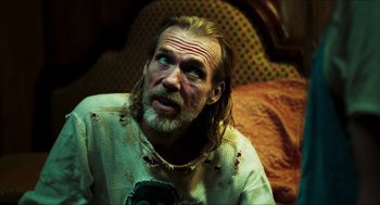 Movie still from “3 from Hell” (2019), directed by Rob Zombie – A person sitting on a bed; Close Up shot, Over the shoulder angle