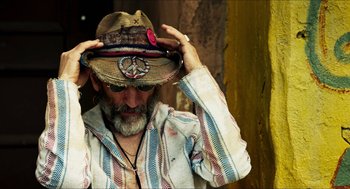 Movie still from “3 from Hell” (2019), directed by Rob Zombie – A man with a peace sign on his hat; Close Up shot, Over the shoulder angle