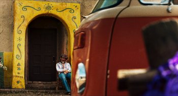 Movie still from “3 from Hell” (2019), directed by Rob Zombie – A man sitting on the side of a building next to a van; Wide shot, Low angle