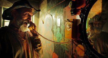 Movie still from “3 from Hell” (2019), directed by Rob Zombie – A man talking on a phone in front of a wall; Close Up shot, Low angle