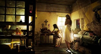 Movie still from “3 from Hell” (2019), directed by Rob Zombie – Two women standing in front of an altar in a room; Wide shot, Low angle