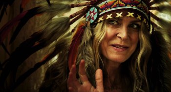 Movie still from “3 from Hell” (2019), directed by Rob Zombie – A person wearing a headdress; Close Up shot, Over the shoulder angle