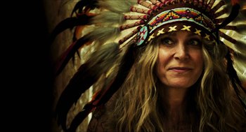 Movie still from “3 from Hell” (2019), directed by Rob Zombie – A person wearing a headdress; Close Up shot, Over the shoulder angle