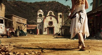Movie still from “3 from Hell” (2019), directed by Rob Zombie – A woman in a white dress standing in front of an old church; Wide shot, Low angle