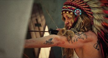Movie still from “3 from Hell” (2019), directed by Rob Zombie – A woman with a bow and arrow in a native american outfit; Close Up shot, Low angle