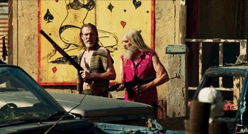 Movie still from “3 from Hell” (2019), directed by Rob Zombie – A couple of men standing next to each other holding guns; Medium shot, Low angle