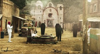 Movie still from “3 from Hell” (2019), directed by Rob Zombie – A couple of people standing next to a cemetery; Extreme Wide shot, High angle