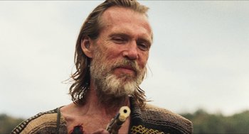 Movie still from “3 from Hell” (2019), directed by Rob Zombie – A person holding a pipe in his mouth; Close Up shot, Over the shoulder angle