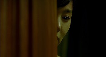 A young girl looking out of a window at night