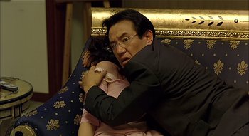 Movie still from “3-Iron” (2004), directed by Kim Ki-duk – A man holding a woman on a couch; Close Up shot, Over the shoulder angle
