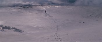 Movie still from “30 Days of Night” (2007), directed by David Slade – A person is walking in the snow on a hill; Extreme Wide shot, High angle