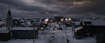 Movie still from “30 Days of Night” (2007), directed by David Slade – People are walking down a snowy street at night; Extreme Wide shot, High angle