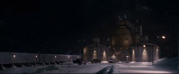Movie still from “30 Days of Night” (2007), directed by David Slade – Cars are parked in front of a grain silo at night; Extreme Wide shot, High angle