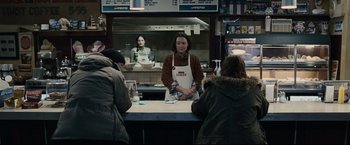Movie still from “30 Days of Night” (2007), directed by David Slade – A woman standing behind a counter at a diner; Medium shot, Over the shoulder angle