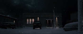 Movie still from “30 Days of Night” (2007), directed by David Slade – A car parked in front of a building at night; Extreme Wide shot, Low angle