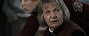 Movie still from “30 Days of Night” (2007), directed by David Slade – An older woman looking at the camera while a younger woman looks on; Close Up shot, Over the shoulder angle