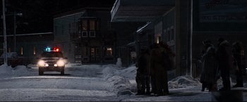 Movie still from “30 Days of Night” (2007), directed by David Slade – A group of people standing in the snow at night; Extreme Wide shot, High angle