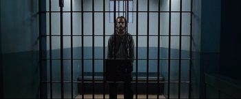 Movie still from “30 Days of Night” (2007), directed by David Slade – A man standing behind bars in a jail cell; Wide shot, Low angle