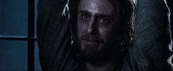Movie still from “30 Days of Night” (2007), directed by David Slade – A person with a beard looking at the camera; Close Up shot, Over the shoulder angle