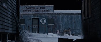 Movie still from “30 Days of Night” (2007), directed by David Slade – A building with a sign on the side of it; Extreme Wide shot, High angle