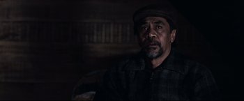 Movie still from “30 Days of Night” (2007), directed by David Slade – A man with a beard and a hat is sitting in a chair; Close Up shot, Over the shoulder angle