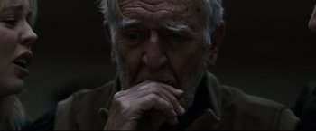 Movie still from “30 Days of Night” (2007), directed by David Slade – An old man with a beard is holding his hands under his chin; Close Up shot, Over the shoulder angle
