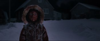 Movie still from “30 Days of Night” (2007), directed by David Slade – A person in a hooded jacket standing in the snow at night; Medium shot, High angle