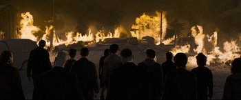 Movie still from “30 Days of Night” (2007), directed by David Slade – A group of people standing in front of a burning building; Wide shot, High angle