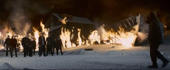 Movie still from “30 Days of Night” (2007), directed by David Slade – People walking in the snow near a burning building; Wide shot, Low angle