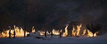 Movie still from “30 Days of Night” (2007), directed by David Slade – A group of people standing in the snow near a fire; Extreme Wide shot, High angle