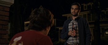 Movie still from “30 Minutes or Less” (2011), directed by Ruben Fleischer – A man standing next to another man holding a beer; Medium shot, Over the shoulder angle
