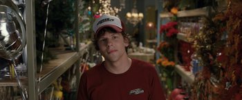 Movie still from “30 Minutes or Less” (2011), directed by Ruben Fleischer – A young man wearing a red shirt and a white hat; Close Up shot, Over the shoulder angle