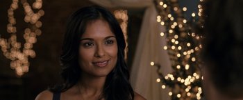 Movie still from “30 Minutes or Less” (2011), directed by Ruben Fleischer – A woman with long black hair smiles for the camera; Close Up shot, Over the shoulder angle