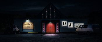 Movie still from “30 Minutes or Less” (2011), directed by Ruben Fleischer – A large building that has lights on the outside of it; Extreme Wide shot, Low angle