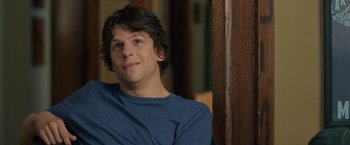 Movie still from “30 Minutes or Less” (2011), directed by Ruben Fleischer – A man sitting in front of a wooden wall; Close Up shot, Over the shoulder angle