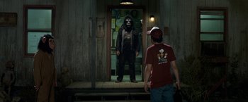 Movie still from “30 Minutes or Less” (2011), directed by Ruben Fleischer – A man standing in front of a man in a gorilla costume; Medium shot, Over the shoulder angle