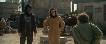 Movie still from “30 Minutes or Less” (2011), directed by Ruben Fleischer – A man wearing a monkey mask standing in front of other people; Medium shot, High angle
