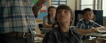 Movie still from “30 Minutes or Less” (2011), directed by Ruben Fleischer – A young boy looks up at a teacher; Close Up shot, Over the shoulder angle