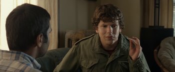 Movie still from “30 Minutes or Less” (2011), directed by Ruben Fleischer – A man sitting on top of a couch in front of a window; Close Up shot, Over the shoulder angle