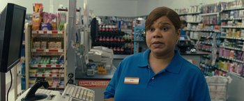 Movie still from “30 Minutes or Less” (2011), directed by Ruben Fleischer – A woman standing in front of a cash register in a store; Close Up shot, High angle