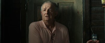 Movie still from “30 Minutes or Less” (2011), directed by Ruben Fleischer – An older man wearing glasses and a pink shirt; Close Up shot, Low angle